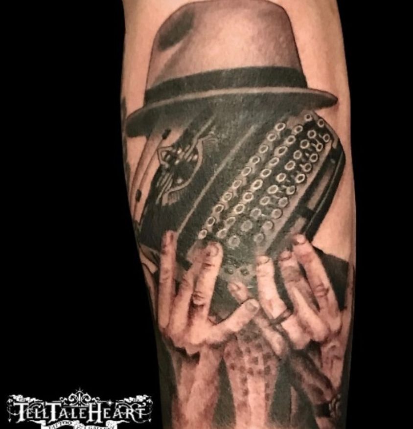 Black and grey naked lunch tattoo David Cronenberg fingers typing on an old typewriter wearing a hat