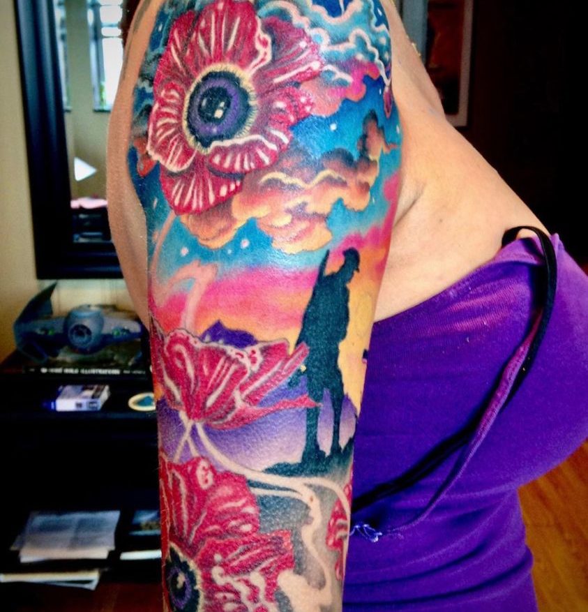 colour remembrance day tattoo sleeve of poppies and a silhouette of a soldier with beautiful clouds and sunset