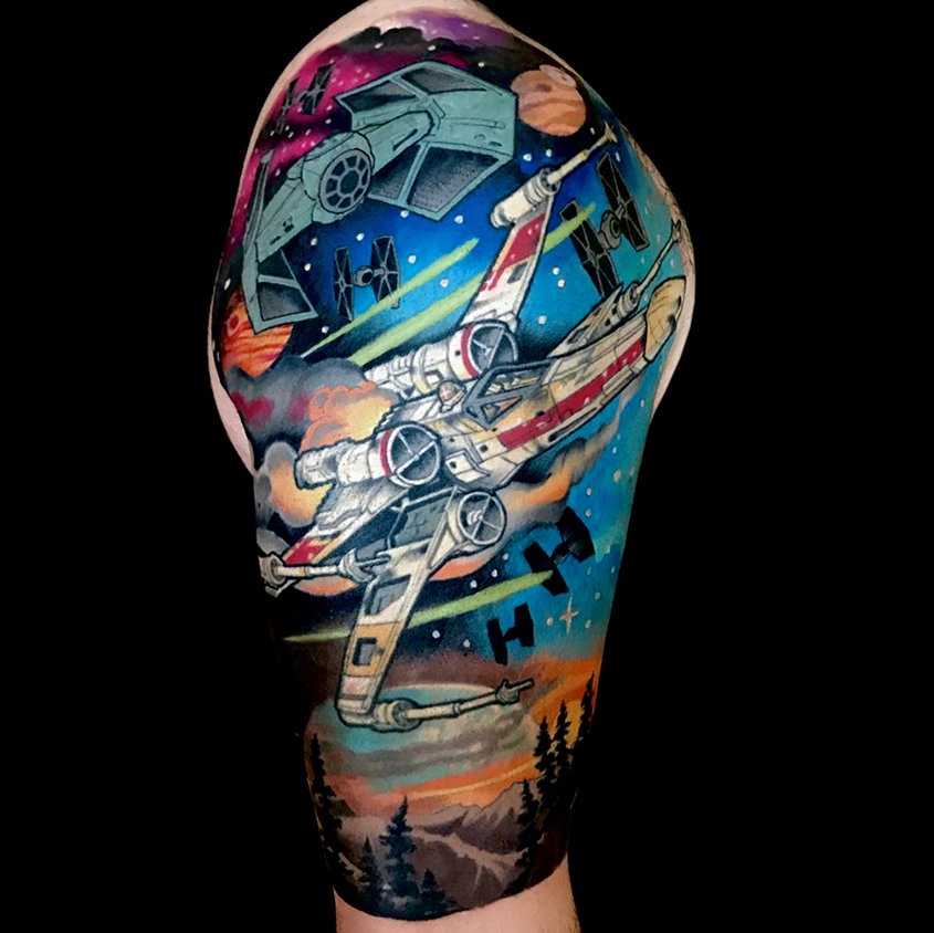 star wars tattoo sleeve featuring damaged x-wing being pursued through a colourful atmosphere by multiple tie fighters with a plantet surface below