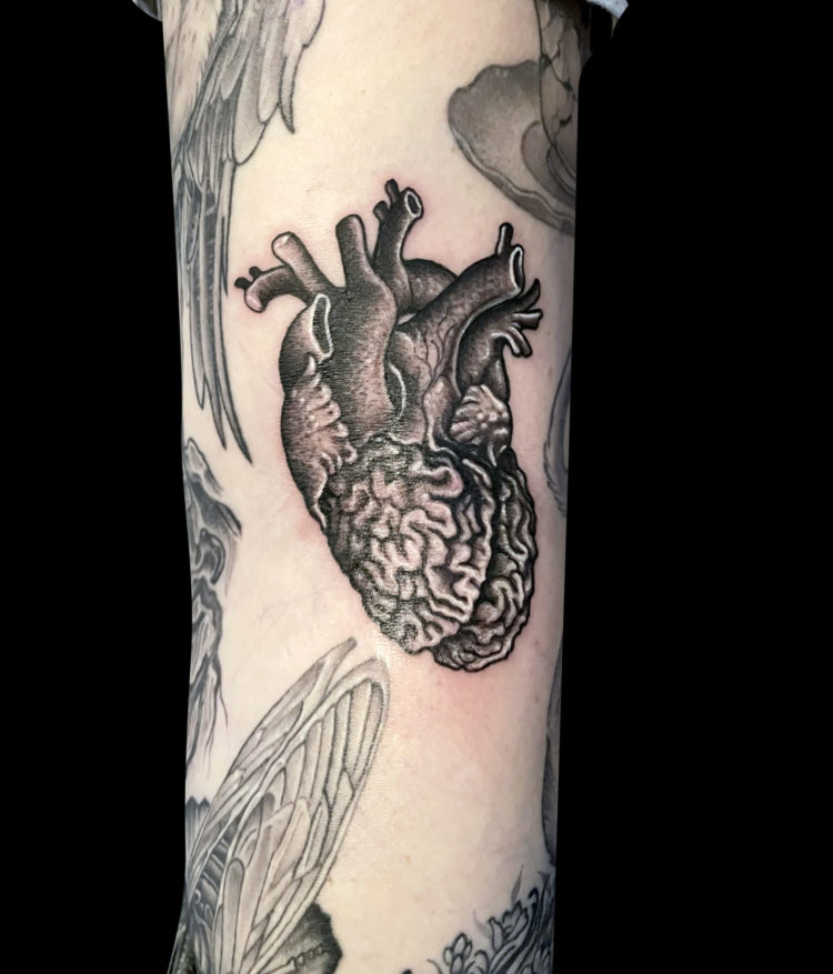 black and grey tattoo of anatomical heart with brain as ventricles