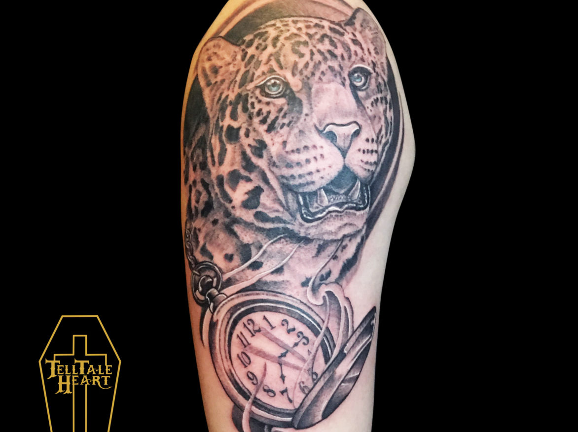 black and grey portrait tattoo of cheetach with blue eyes and open pocket watch underneath tattooed on right outside shoulder