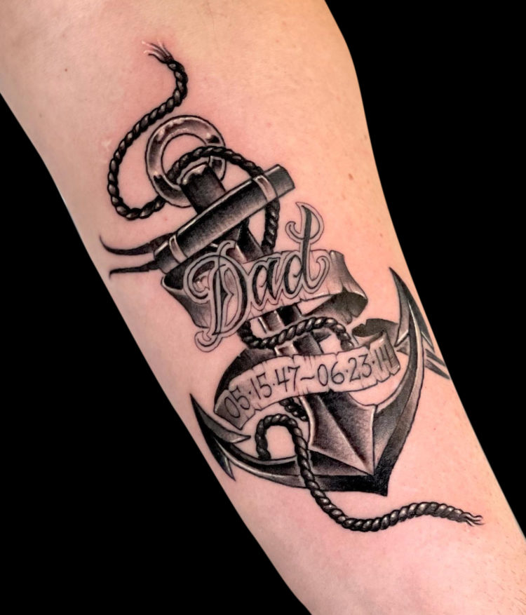 black and grey tattoo of traditional anchoe with banner that reads DAD and birth and death date