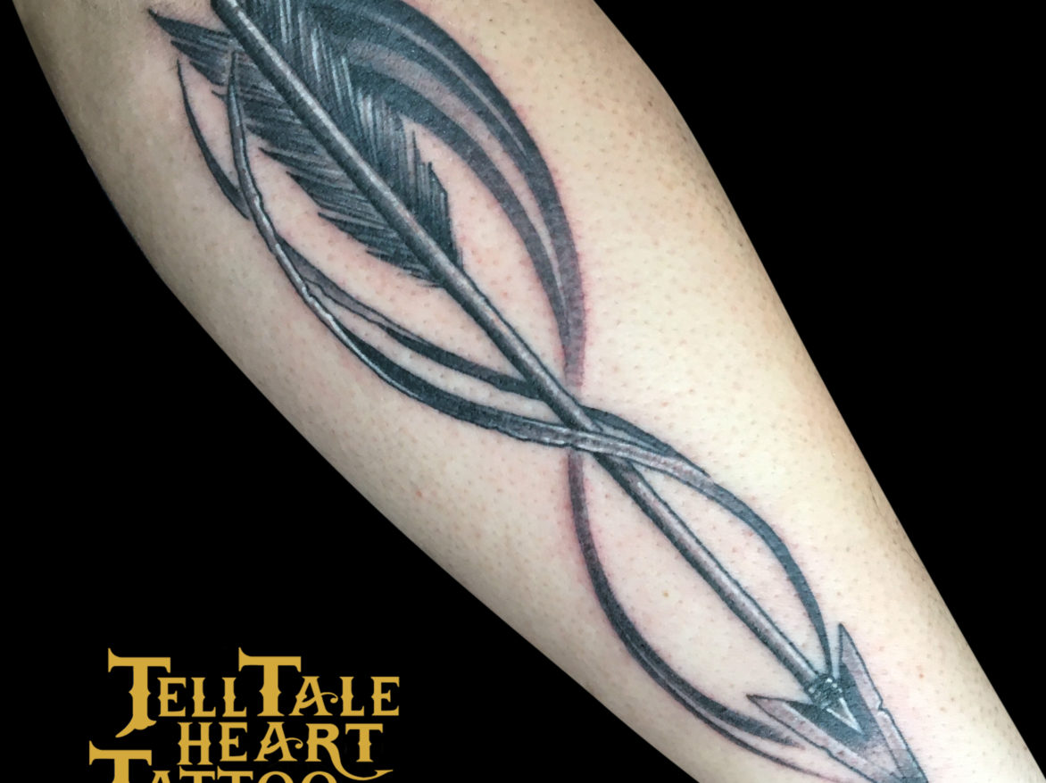 black and grey tattoo of arrow with infinity symbol tattooed on forearm