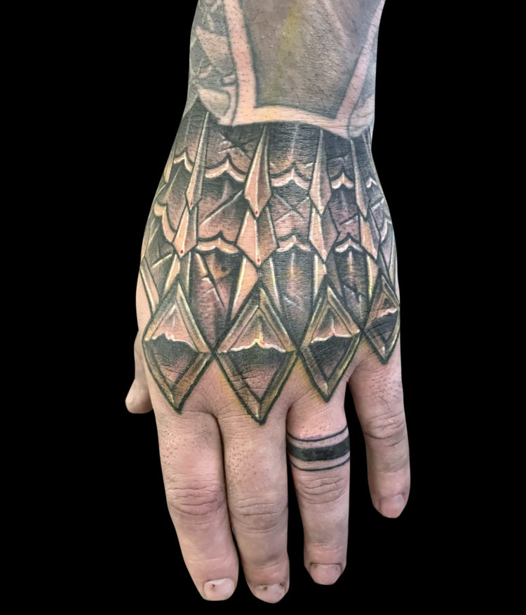 black and grey tattoo of metal armour tattoo on hand