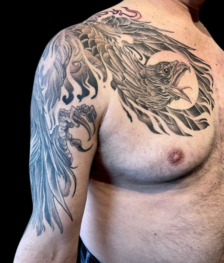 Black and grey tattoo sleeve of screaming phoenix that comes over onto chest with moon in background and negative space flames and prominent claw
