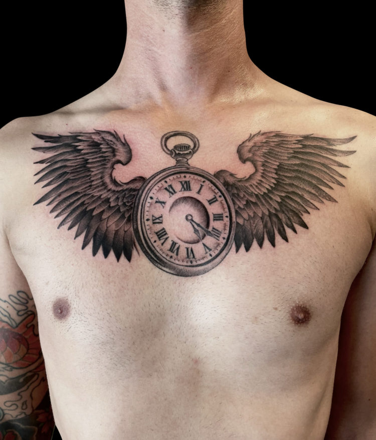 black and grey realism tattoo of open pocket watch with wings on chest