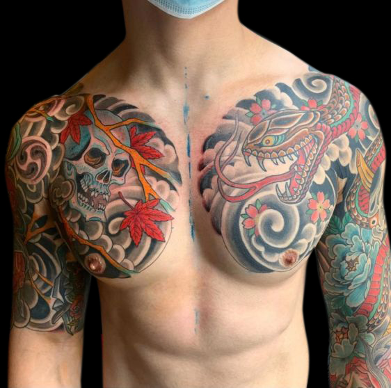 Japanese traditional tattoo sleeves with chest panels featuring a snake motif on one side and skull on the other with Japanese wind bars in background