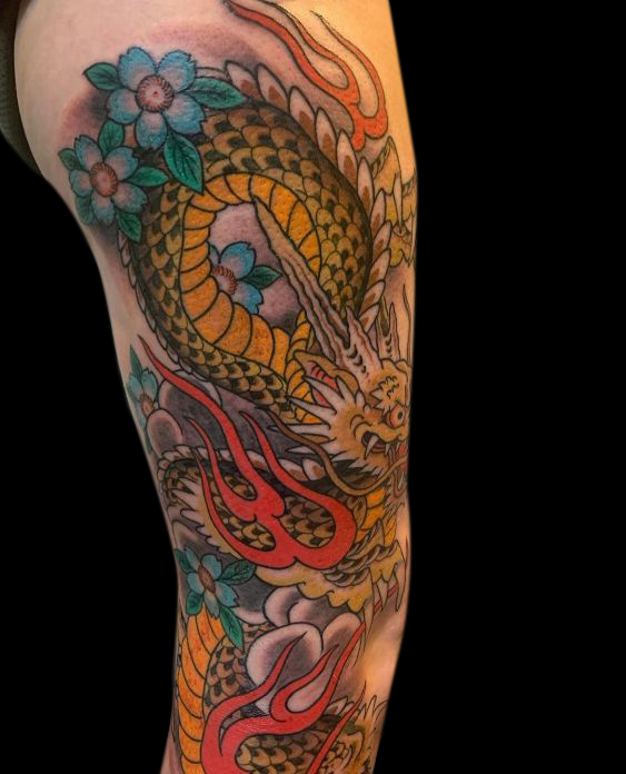 Japanese traditional tattoo of dragon in organge and yellow with blue flowers and red flames on entire right leg from thigh to ankle