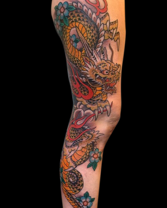 Japanese traditional tattoo of dragon in organge and yellow with blue flowers and red flames on entire right leg from thigh to ankle