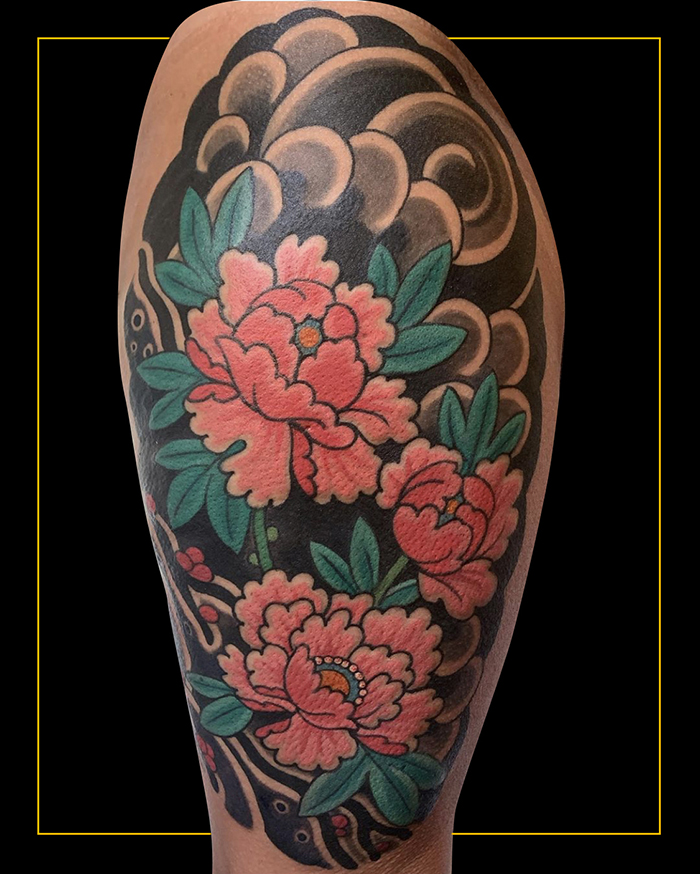 Japanese traditional tattoo of three pink peonies with leave on a backgroudn of black wind bars tattooed on front of thigh