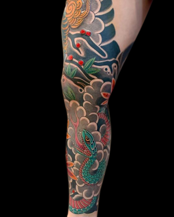 Japanese traditional leg tattoo of green snake, wind bars, clouds