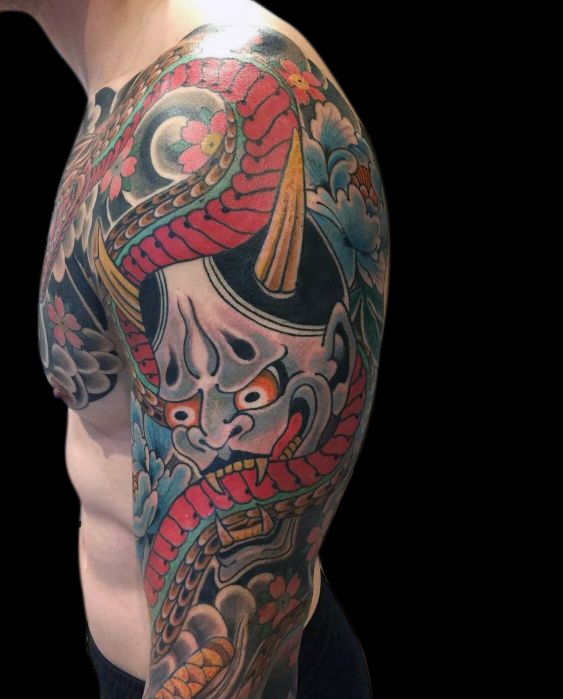 Detail of Japanese hanya mask on bicep surrounded by snake