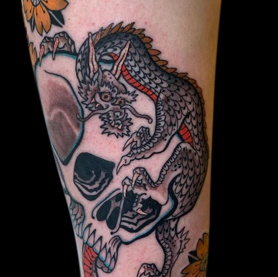 detail of Japanese dragon tattoo perched on top of a skull