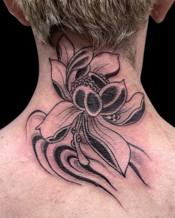 black and grey tattoo of a lotus flower on the back of neck