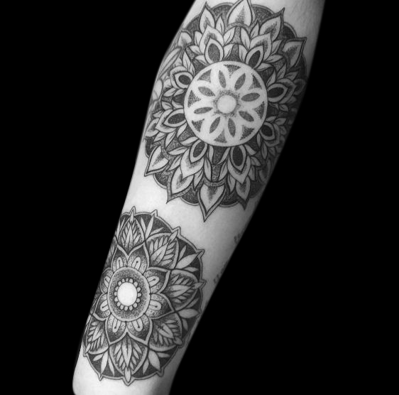 two dotwork mandalas tattooed on forearm