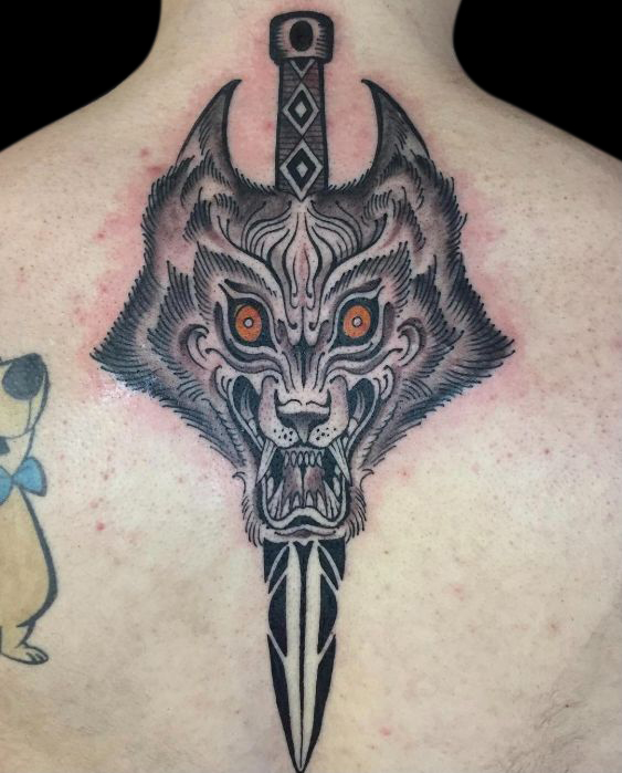 Japanese wolf tattoo with sword behind its head and orange eyes