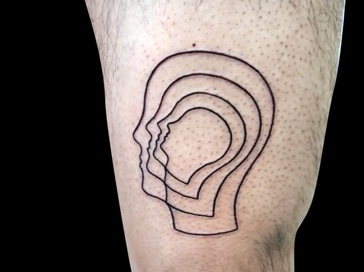 fineline tattoo of four concentric outlines of a human head tattooed on front of thigh