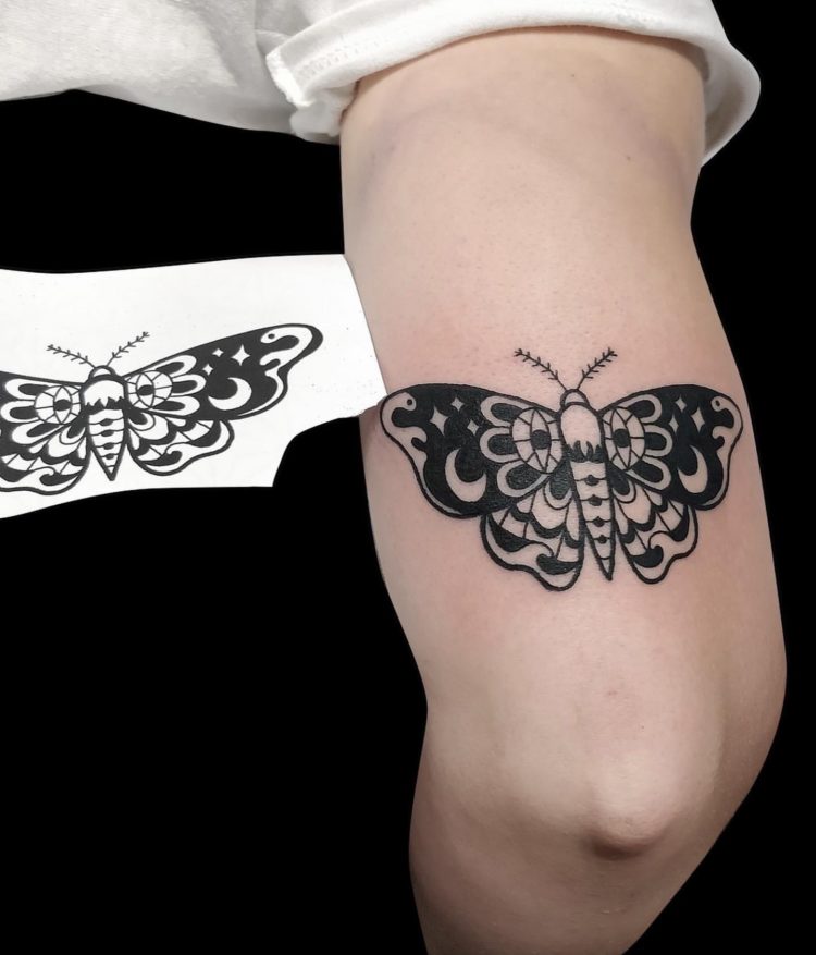 blackwork tattoo of a butterfly tattooed o back of arm
