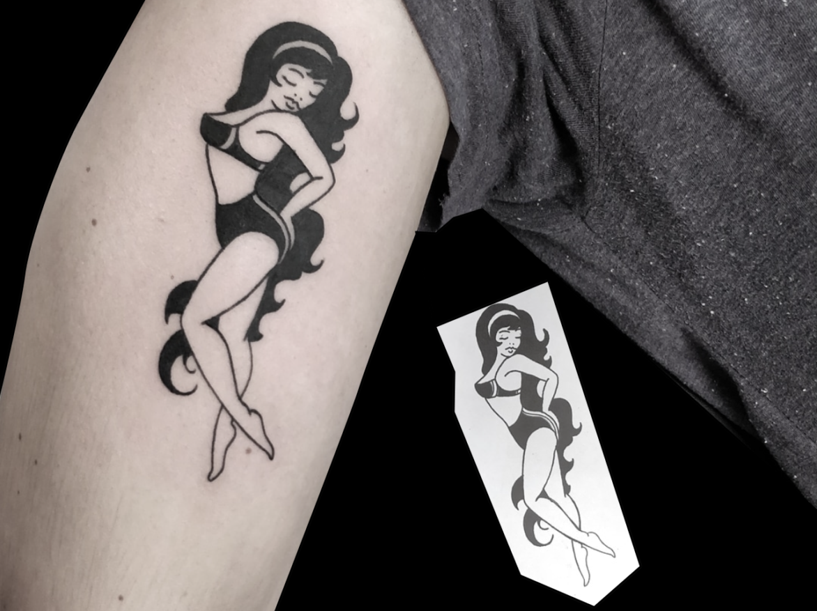 blackwork tattoo of pinup lady with long wavy black hair wearing a bikini looking over her shoulder