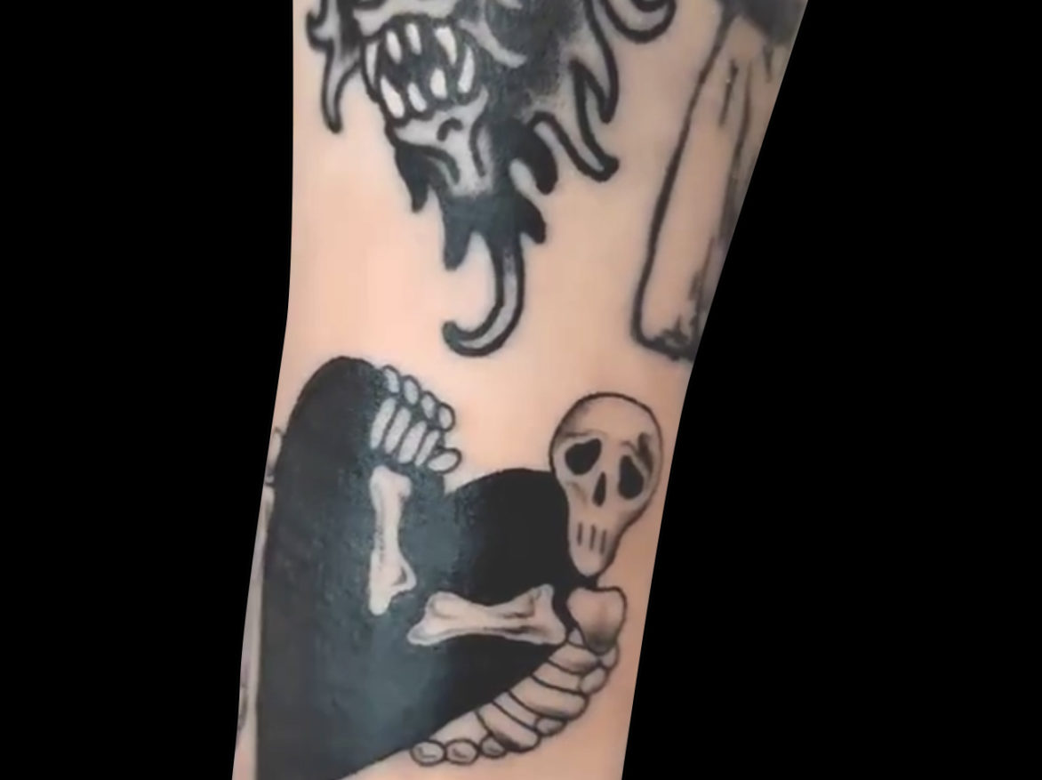 blackwork tattoo of sad looking skeleton holding a solid black heart