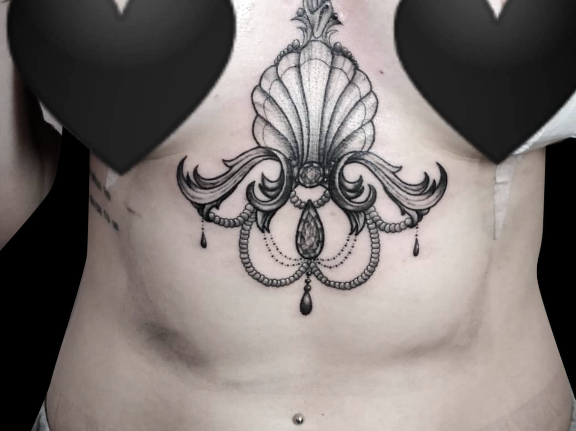 decorative ornamental tattoo of clam shell design with jewels in black and grey tattooed on sternum