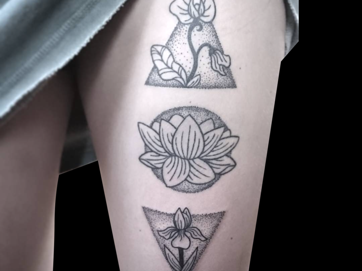 tattoo of three geometric shapes with different flowers in them stacked on top of each other tattooed on front of thigh