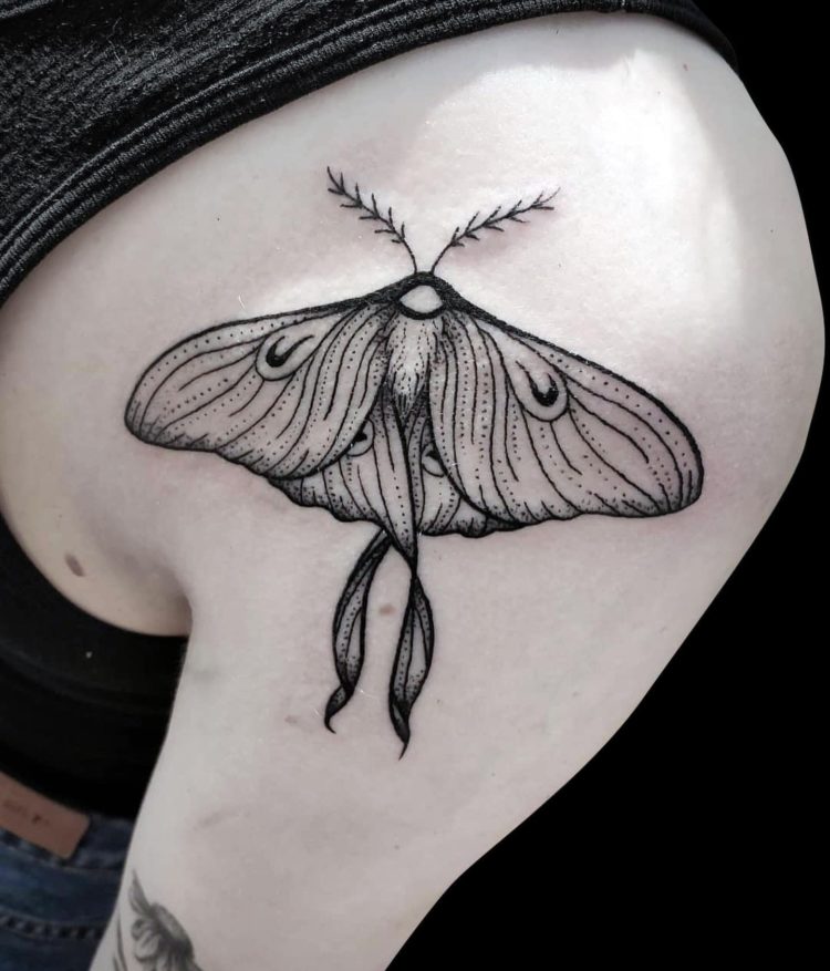 blackwork tattoo of moth with simple lines tattooed on front of shoulder