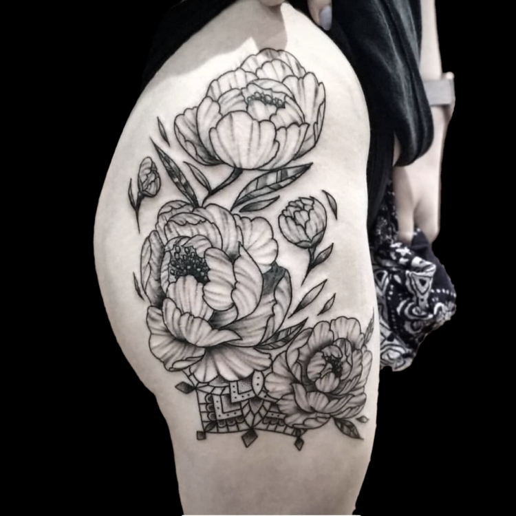 black and grey floral tattoo of three large peonies shaded with simple lines tattooed on the side of a hip and thigh