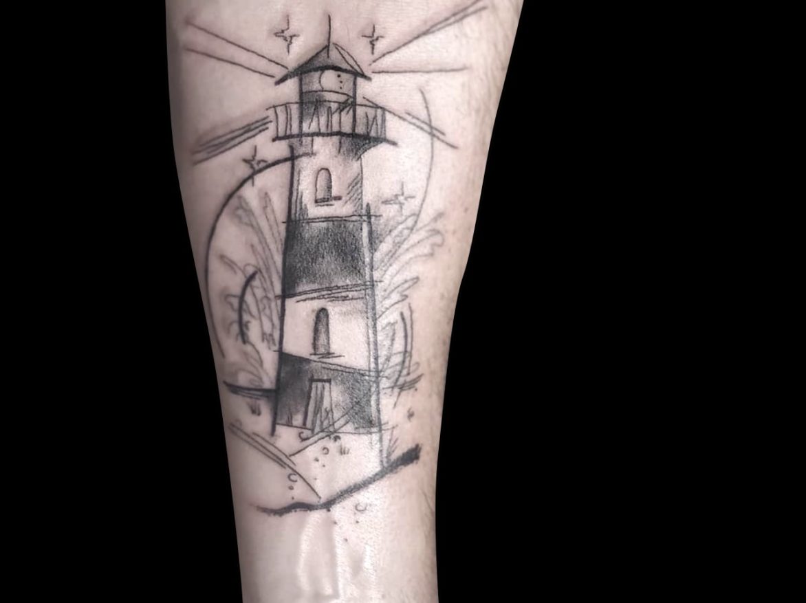 sketchy tattoo of lighthouse with loose sketchy lines of water and light rays with stars on forearm