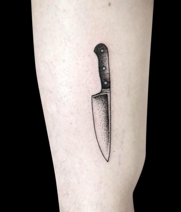 micro tattoo of chef's knife profile shaded with dotwork on side of leg