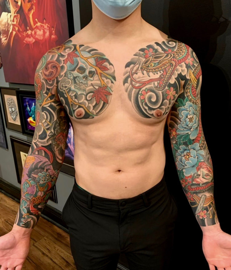 Man with colour Japanese tattoo sleeves on both arms extending onto chest