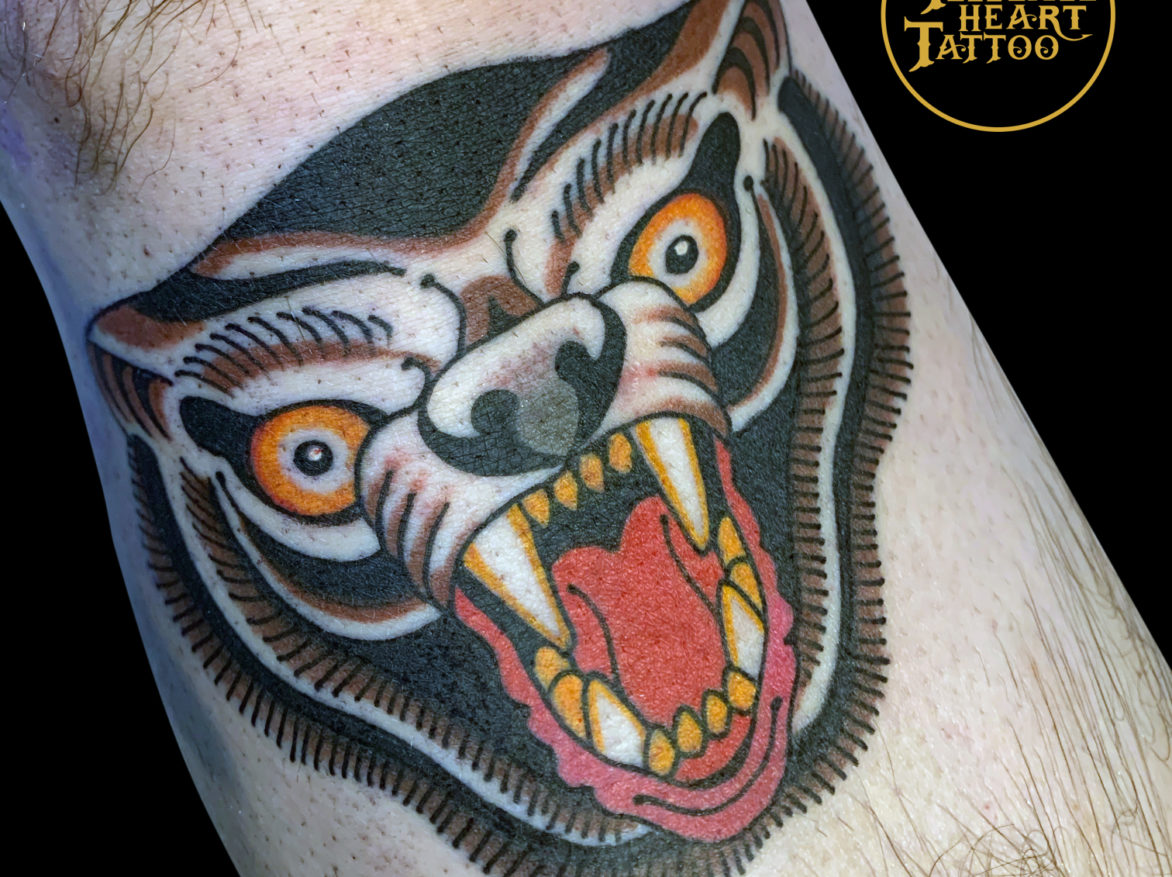 stylized colour tattoo of a snarling brown bear head