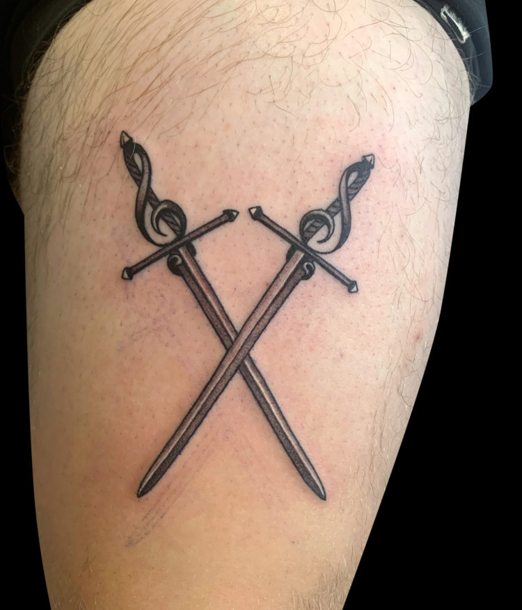 black and grey tattoo of a pair of simple crossed swords