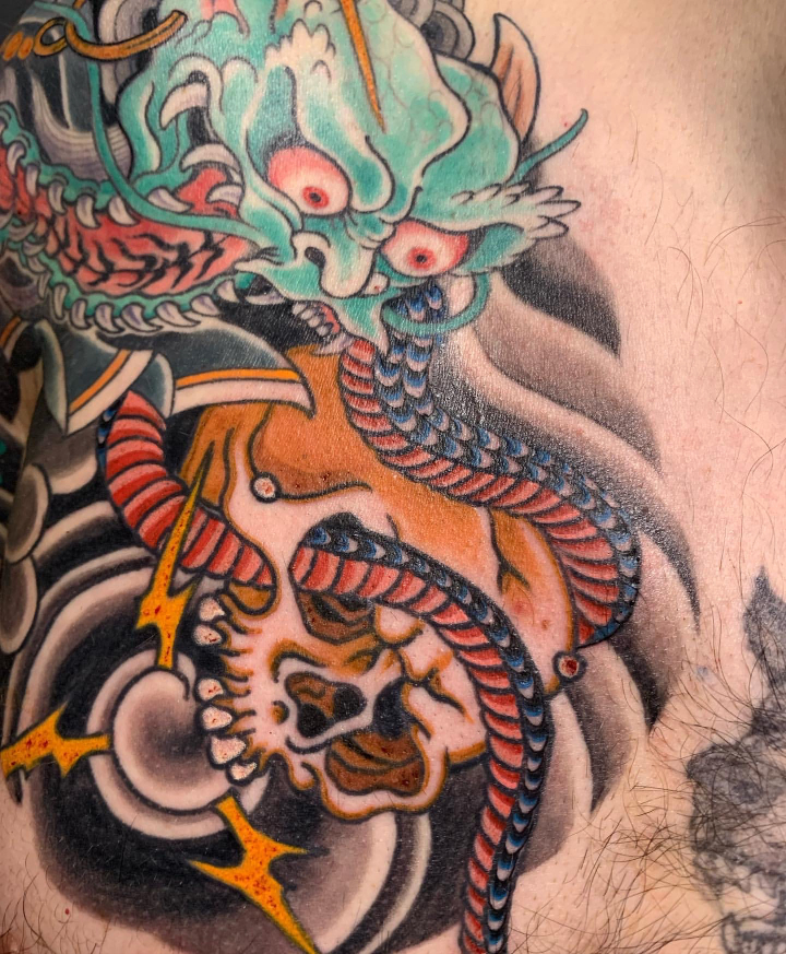 Colour Japanese tattoo detail of green demon and skull