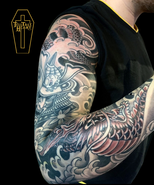 black and grey Japanese tattoo sleeve featuring dragon, samurai helmet, water and wind bars