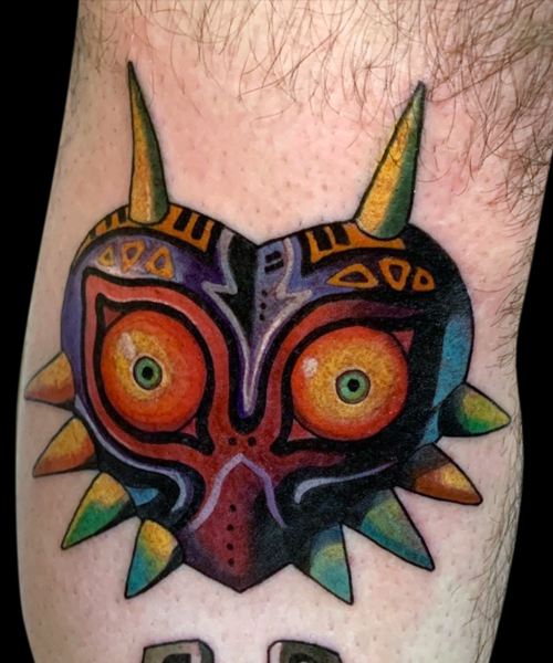 Colour tattoo of Legend of Zelda video game Majora's Mask - colourful heart shaped mask with big eyes, small pupuls and horns