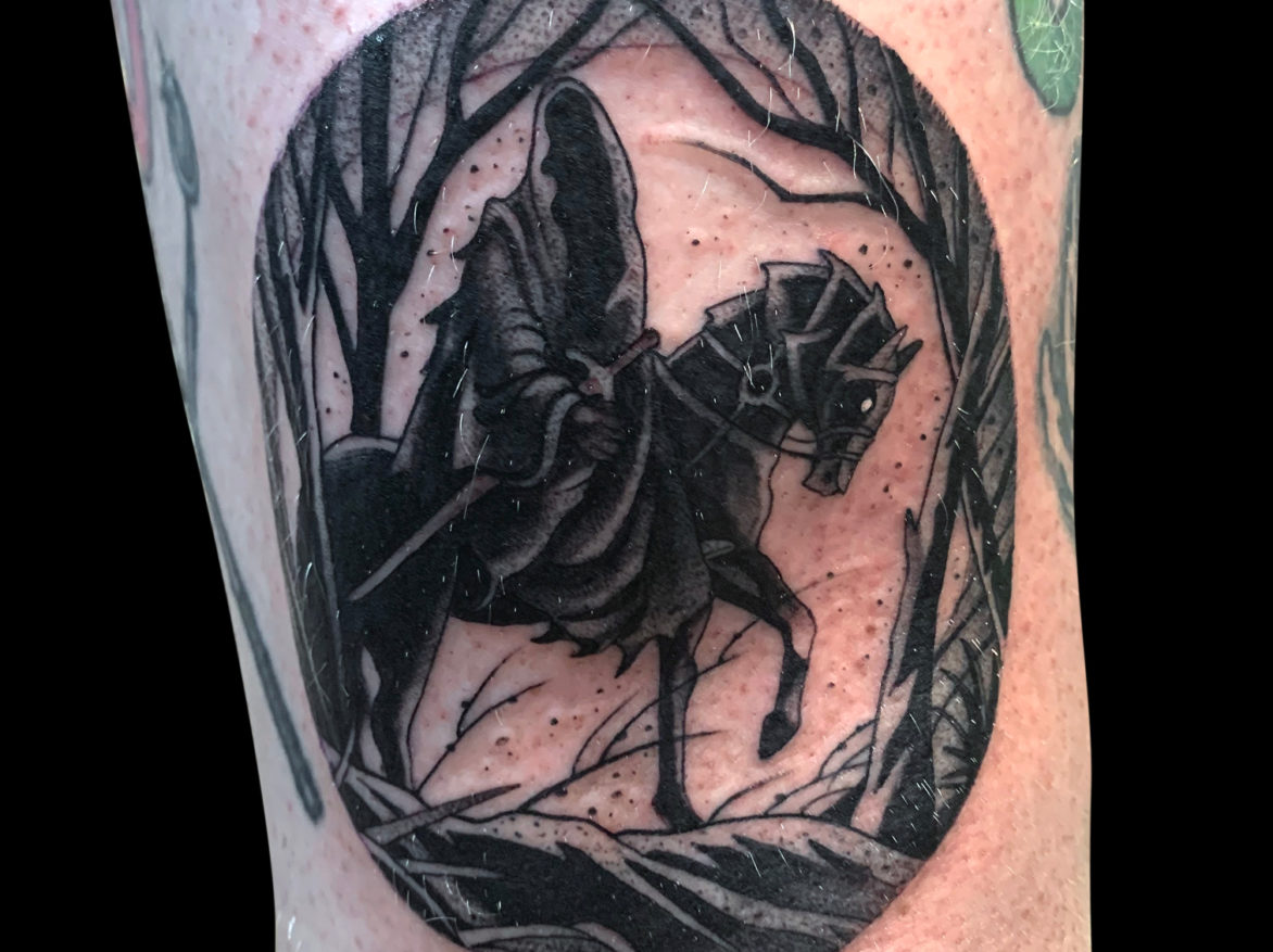 black and grey Lord of the Rings themed tattoo of ring wraith on black horse in oval shape of woods