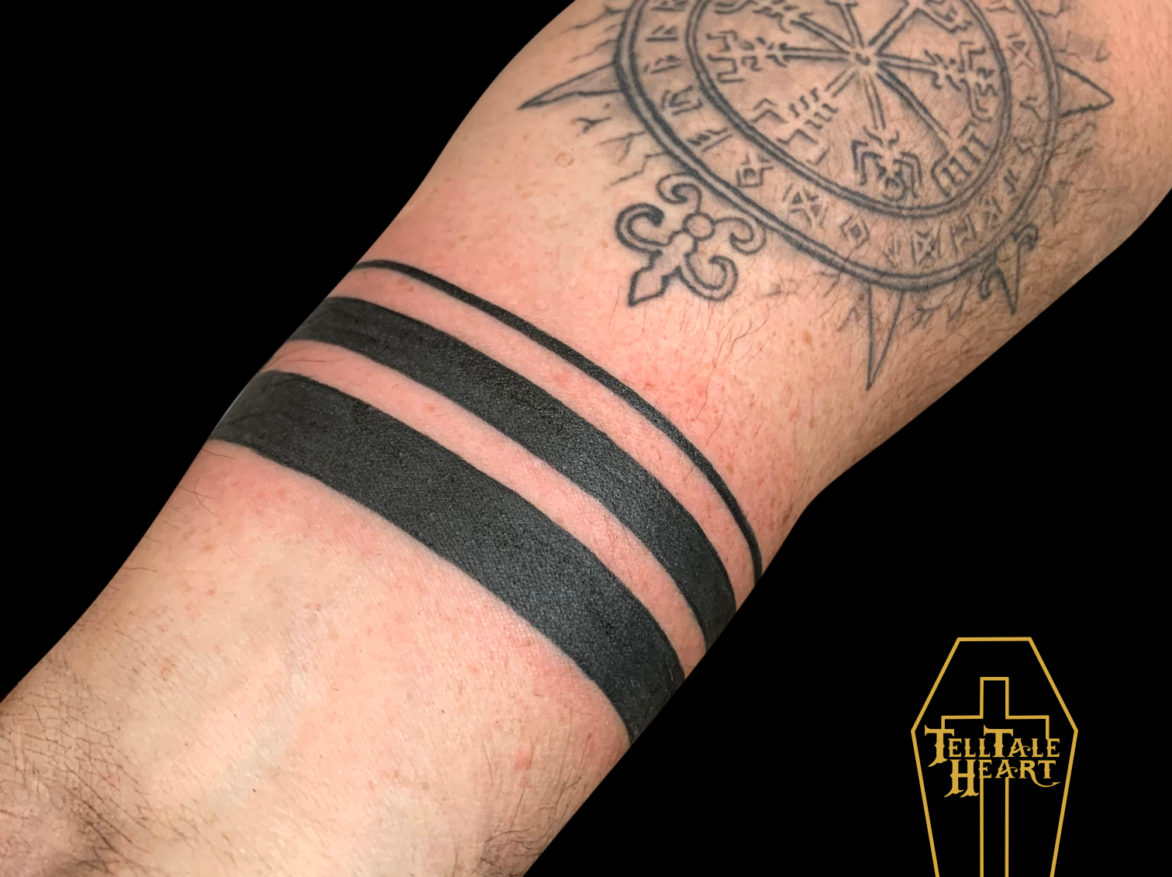 Three solid black bars each thinner than the next tattooed on a wrist.